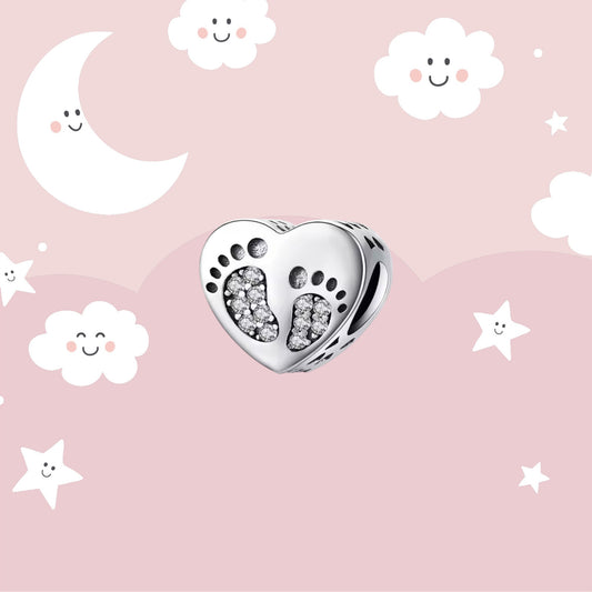 Charm huellas de bebé con circonitas sobre un corazón en plata 925. 